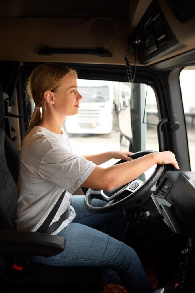Conductrice professionnelle au volant d’un camion, ceinture attachée