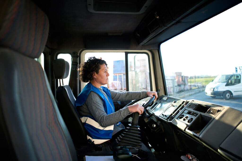 Conductrice professionnelle au volant d’un camion, les deux mains sur le volant